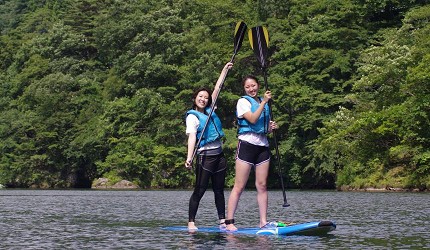 日本關東栃木縣日光市旅遊必去景點推薦兩位女孩在川治溫泉小網水壩湖面上體驗SUP