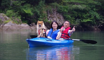 日本關東栃木縣日光市旅遊必去景點推薦爸爸媽媽與褐色的狗在川治溫泉小網水壩湖面上體驗划獨木舟